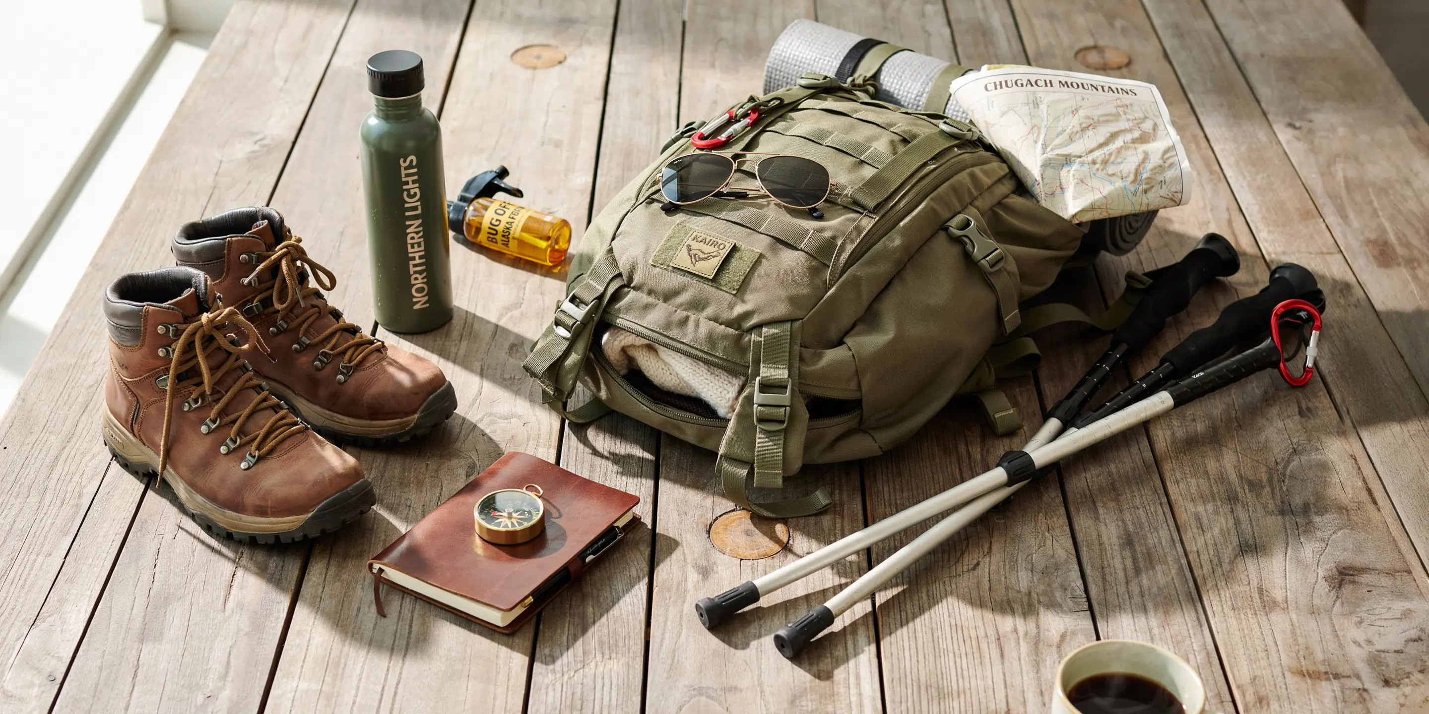 voyini flat lay of hiking gear on wooden cabin table